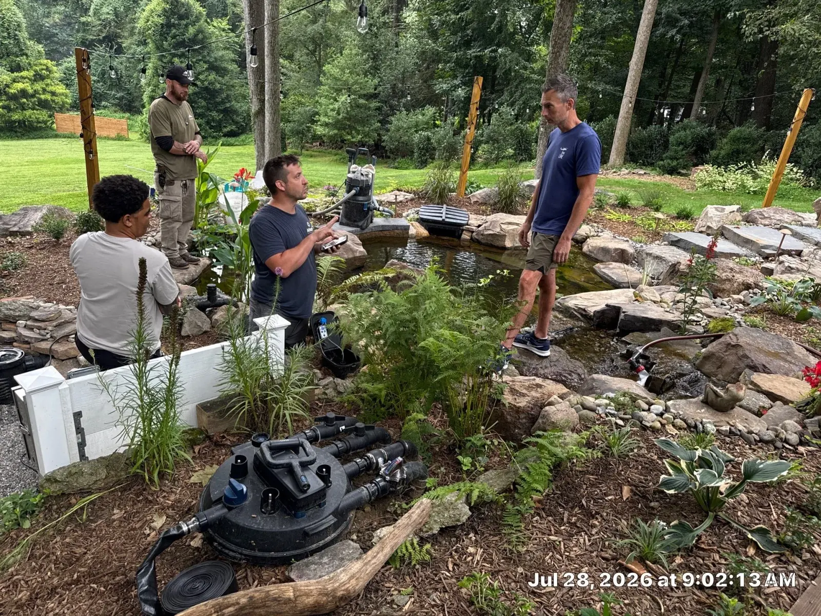 Rock Water Ponds team reviewing equipment and water conditions during a professional pond maintenance visit