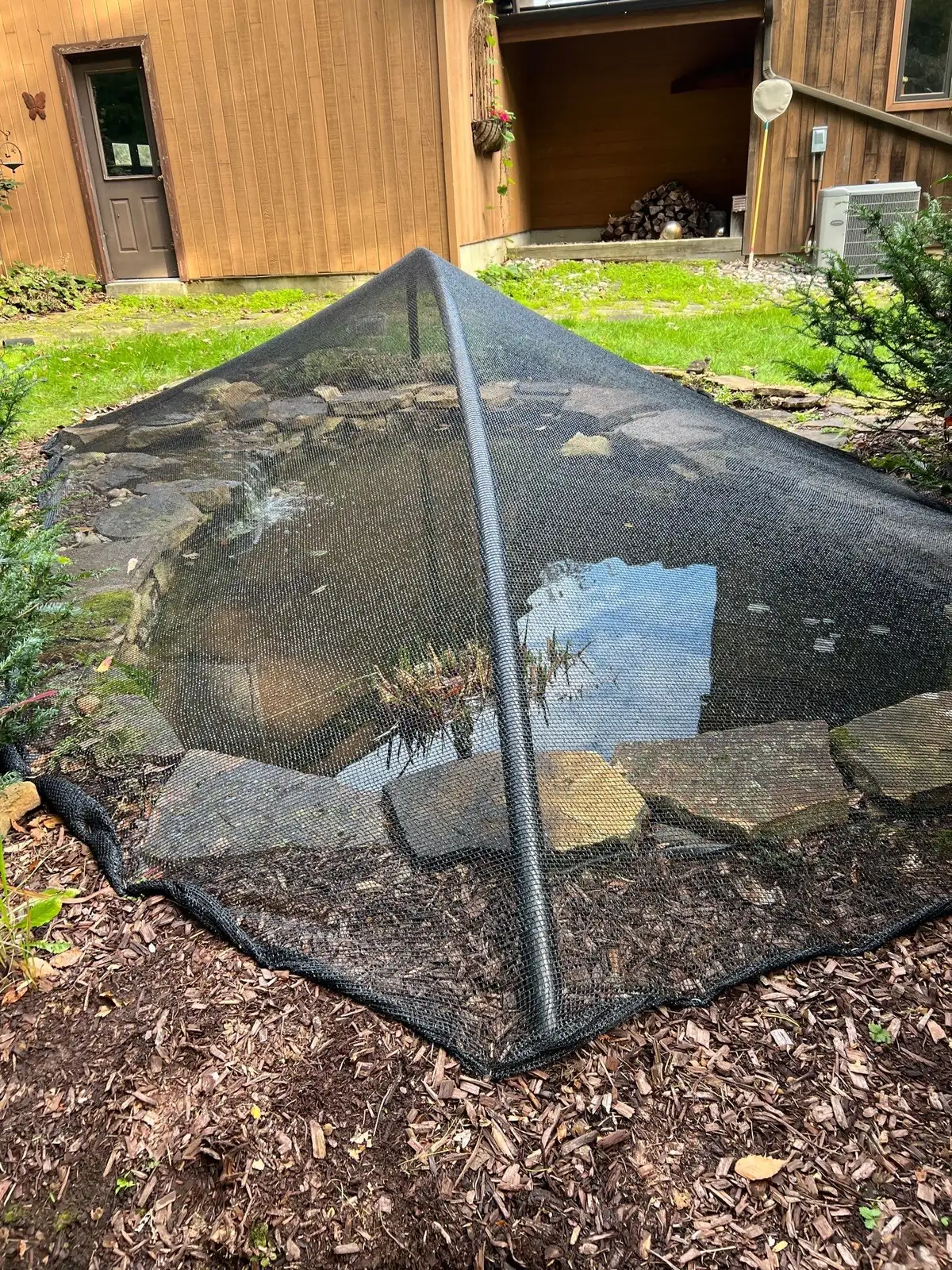 Fall netting installed over a pond to manage leaf debris