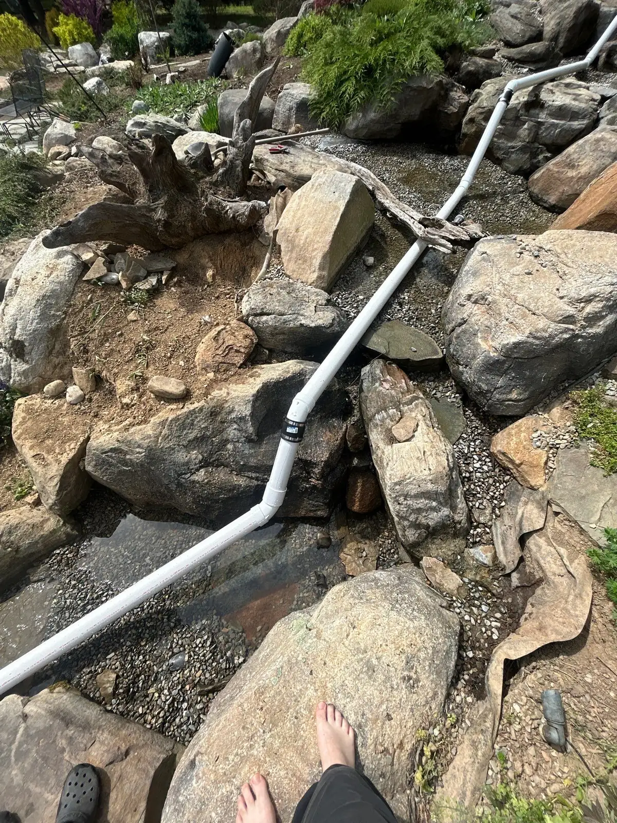 Pond leak diagnostic service checking water loss around a backyard pond